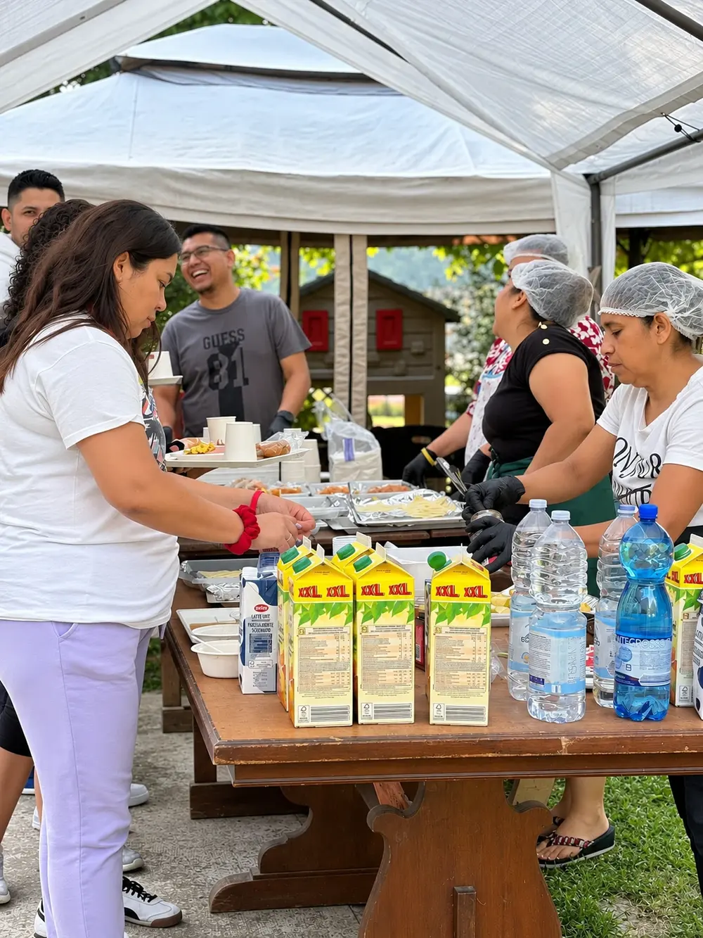 Voluntarios sirviendo el buffet bajo un toldo